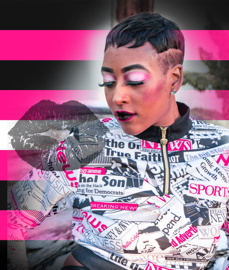 a bipoc femme with pink makeup and black and pink lips, wearing a newpaper print hoodie, with the queer femme pride flag framing her. lgbtqai, transfemme, transgender femme, nonbinary femme, bi-gender femme, pride flags